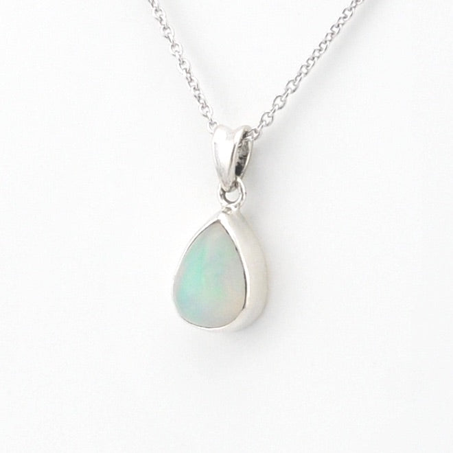 A silver teardrop pendant necklace featuring a smooth, iridescent white opal gemstone, shown on a delicate silver chain against a clean white background.