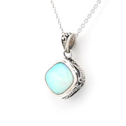 A silver pendant necklace featuring a square-shaped light blue opal stone in an ornate, textured silver bezel setting, suspended from a delicate silver chain against a plain white background.