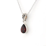 A silver teardrop pendant necklace featuring a dark red gemstone, shown on a clean white background.
