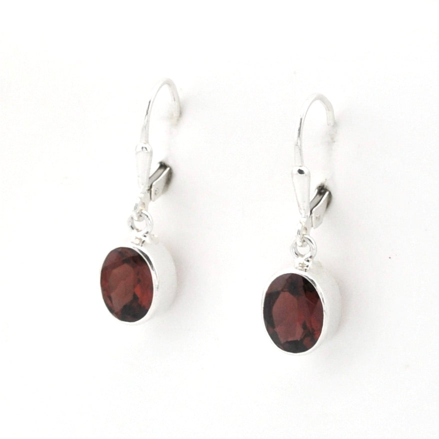 A pair of silver leverback earrings with oval dark red garnet gemstones, shown on a plain white background.