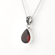 A silver teardrop pendant necklace featuring a faceted dark red gemstone, shown on a clean white background.