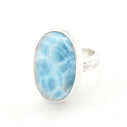 A silver ring featuring an oval-shaped light blue marbled stone, set against a plain white background.