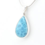 A teardrop-shaped Larimar pendant necklace in a silver bezel setting on a silver snake chain, shown against a plain white background.