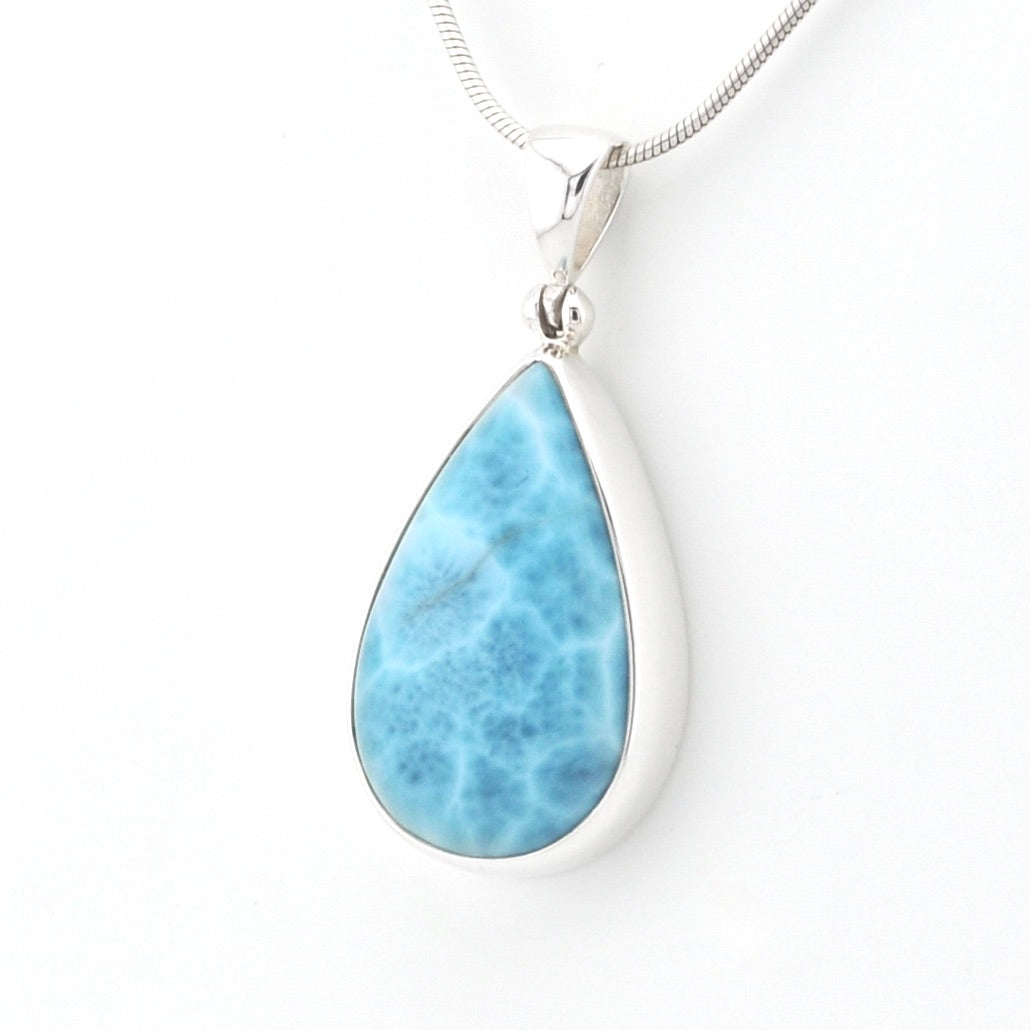 A teardrop-shaped Larimar pendant necklace in a silver bezel setting on a silver snake chain, shown against a plain white background.