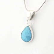 Teardrop-shaped blue pendant on a white background