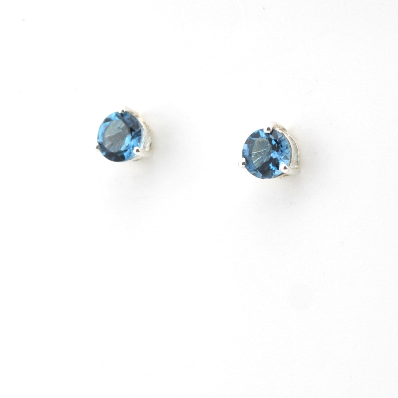 Pair of silver earrings with blue gemstones on a white background