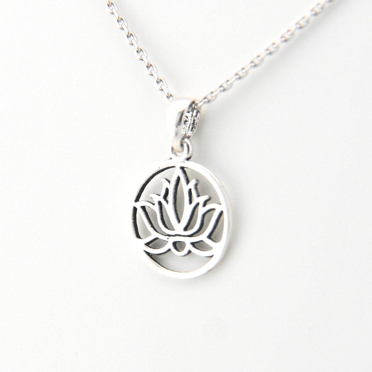 Silver necklace with a lotus flower pendant on a white background