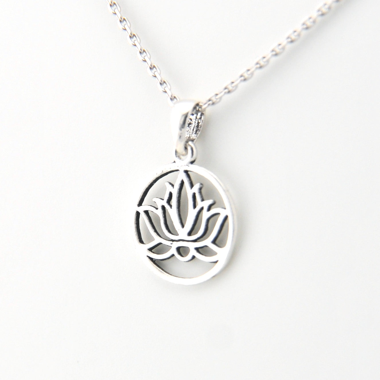 Silver necklace with a lotus flower pendant on a white background