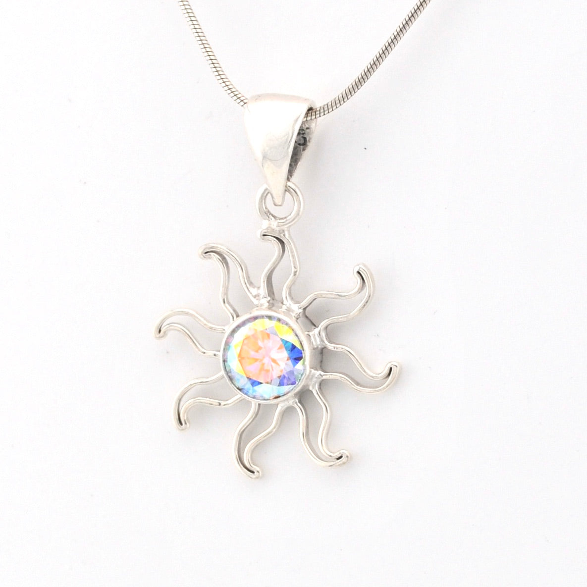 Silver sun-shaped pendant with a colorful center on a white background