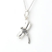 A silver dragonfly pendant necklace on a delicate silver chain, photographed against a clean white background.