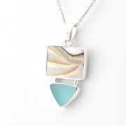 A silver pendant necklace featuring a square nautilus shell with wavy cream and tan patterns, and a dangling light blue teardrop-shaped sea glass, shown on a white background.