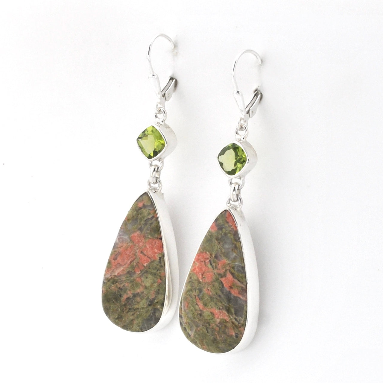 A pair of silver drop earrings featuring marquise-cut olive green peridot gemstones and teardrop-shaped natural jasper stones with green and reddish-brown marbling, set against a plain white background.