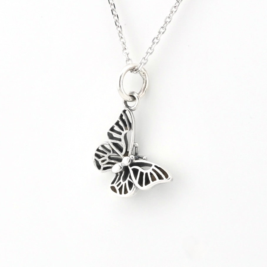 Silver butterfly charm on a gray background