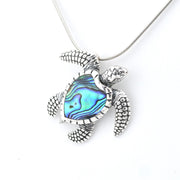 Turtle-shaped pendant with abalone shell inlay on a white background