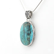 An oval pendant necklace featuring a turquoise-blue marbled stone in a silver-toned metal bezel setting, suspended from a matching silver chain against a plain white background.