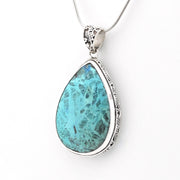 A teardrop-shaped turquoise pendant necklace with a silver-toned ornate bezel setting and chain, shown against a plain white background.