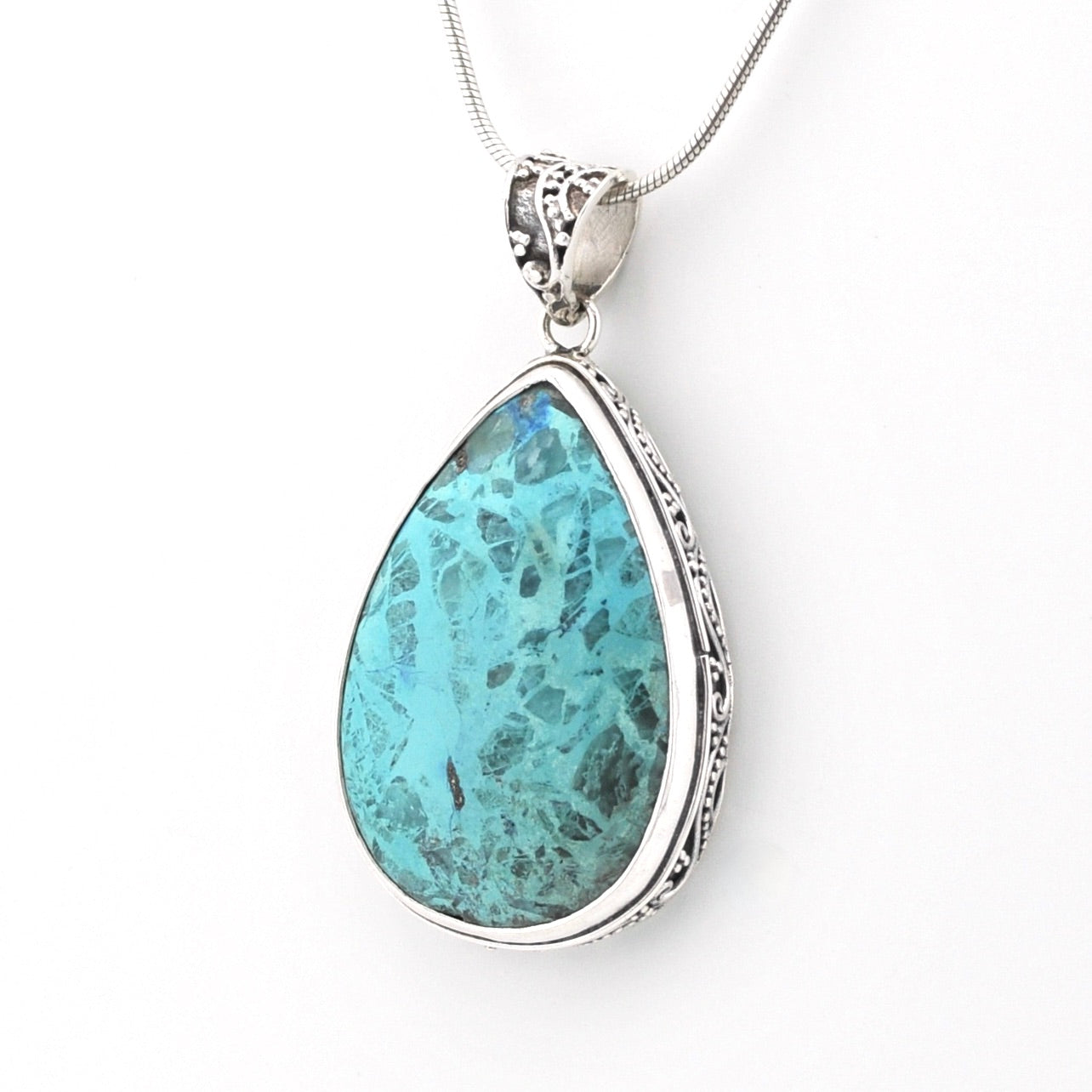 A teardrop-shaped turquoise pendant necklace with a silver-toned ornate bezel setting and chain, shown against a plain white background.