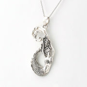 A sterling silver pendant necklace featuring a mermaid design with detailed scrollwork and a textured scale tail, shown on a clean white background.