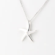 A silver starfish pendant necklace on a delicate silver chain, photographed against a clean white background.