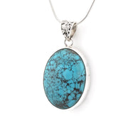 An oval turquoise pendant necklace with a silver-toned bezel and chain, shown against a plain white background.