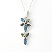 A silver pendant necklace featuring a floral design with marquise-cut blue and olive green gemstones, shown against a plain white background.