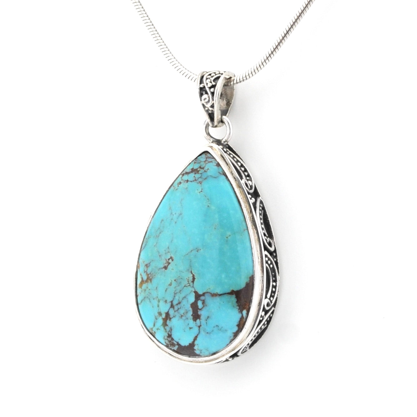 A silver teardrop pendant necklace featuring a turquoise stone with natural brown matrix veining, suspended from a delicate silver chain against a plain white background.