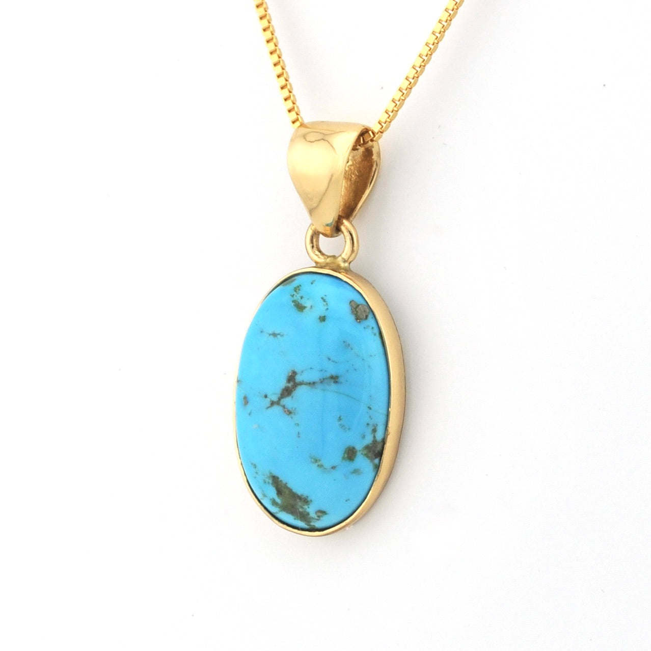 Gold pendant with a turquoise stone on a white background