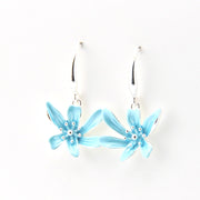 Light blue flower-shaped earrings on a white background