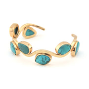 Gold bracelet with turquoise stones on a white background