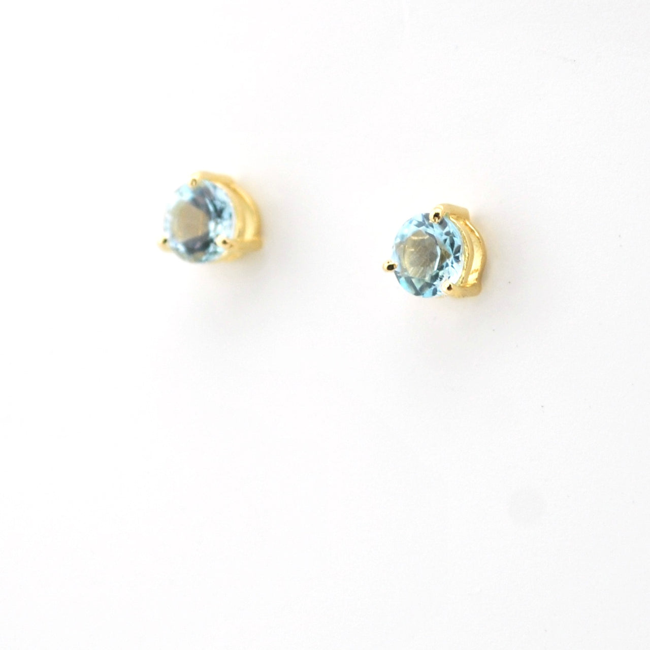 Pair of gold earrings with blue gemstones on a white background