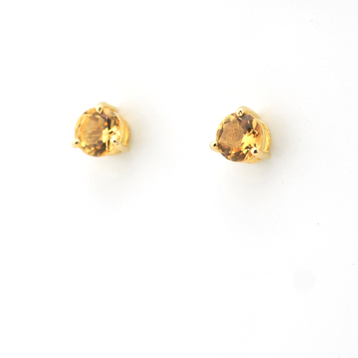Pair of gold stud earrings with round gemstones on a white background