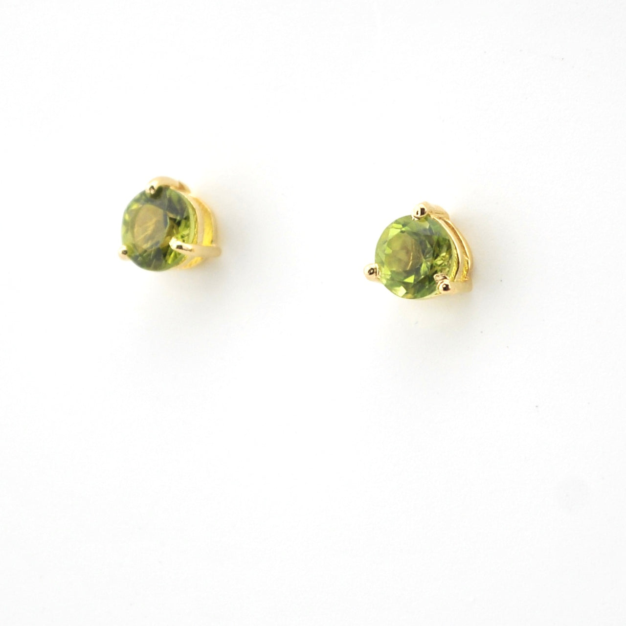 Pair of gold stud earrings with green gemstones on a white background