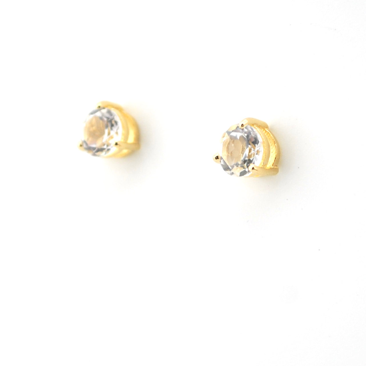Gold earrings with clear gemstones on a white background