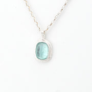 Necklace with a pendant featuring a aqua Roman glass on a white background