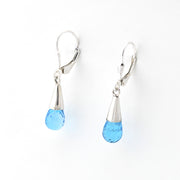 Pair of silver earrings with blue teardrop-shaped drops on a white background