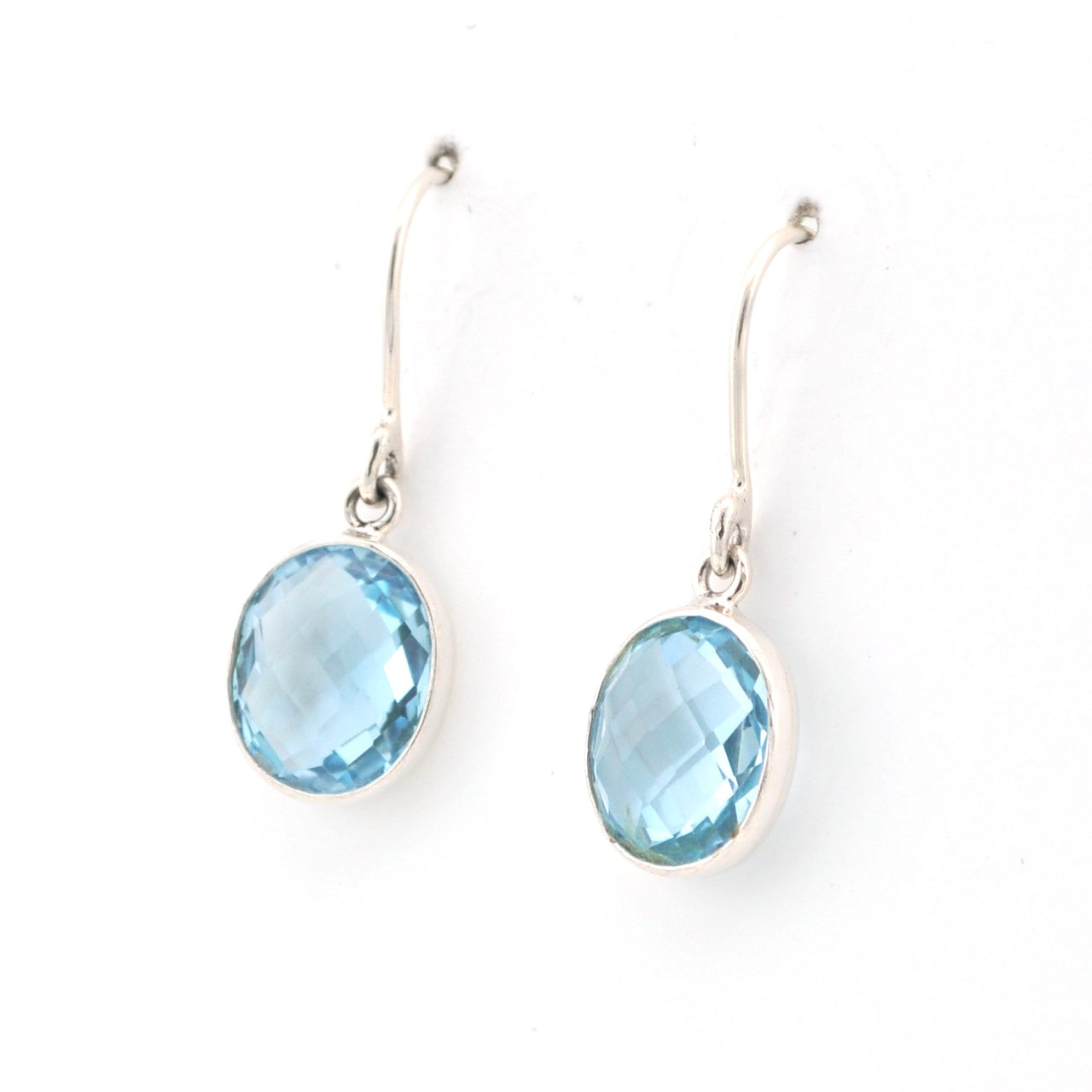 Pair of silver earrings with blue gemstones on a white background
