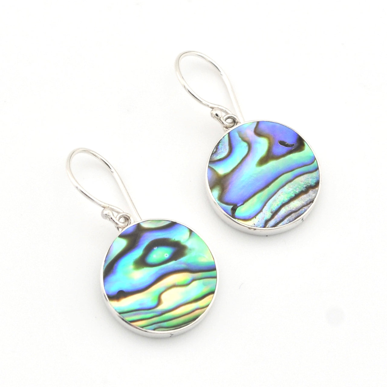 Pair of earrings with colorful abalone shell discs on a white background