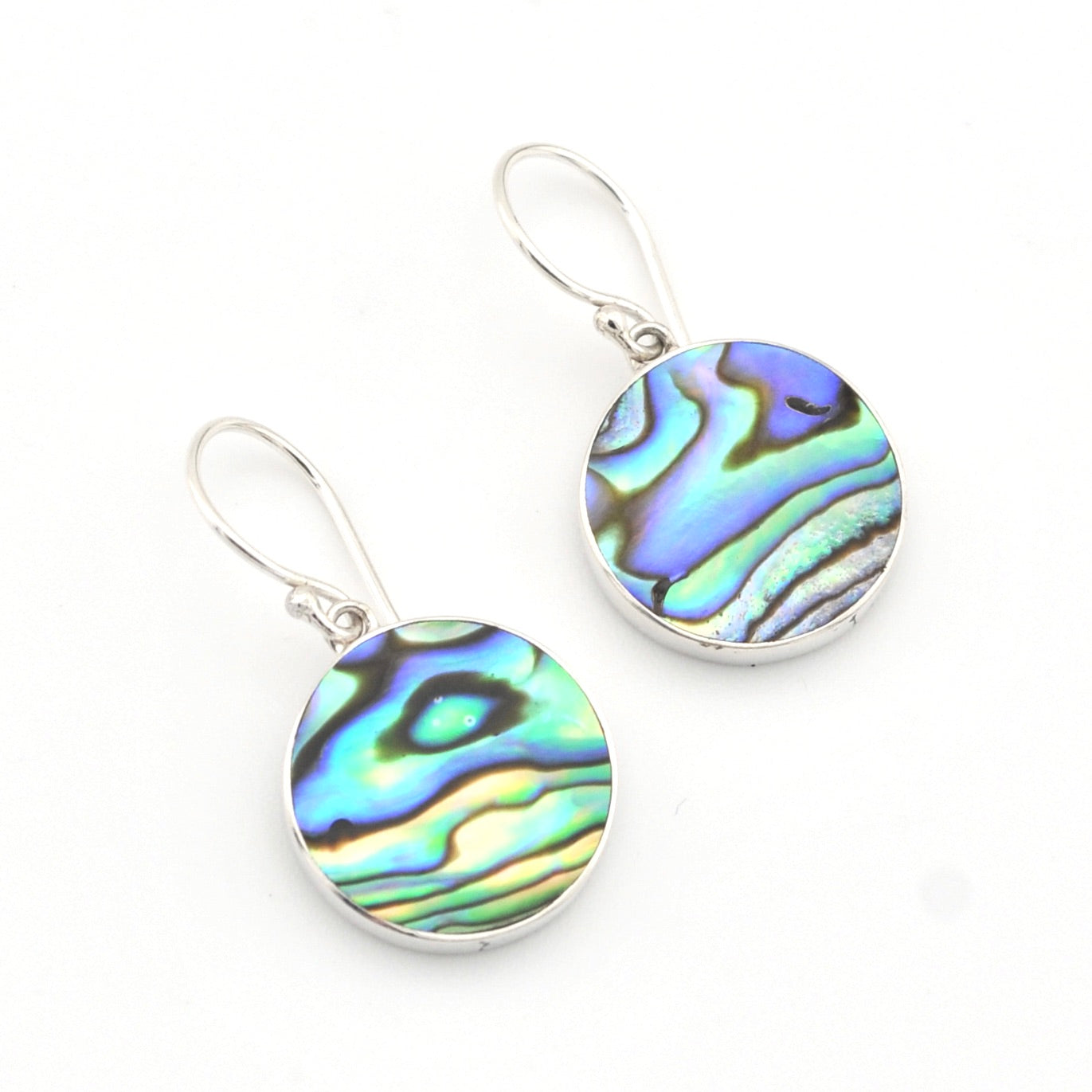 Pair of earrings with colorful abalone shell discs on a white background