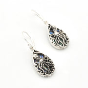 Silver earrings with intricate designs on a white background