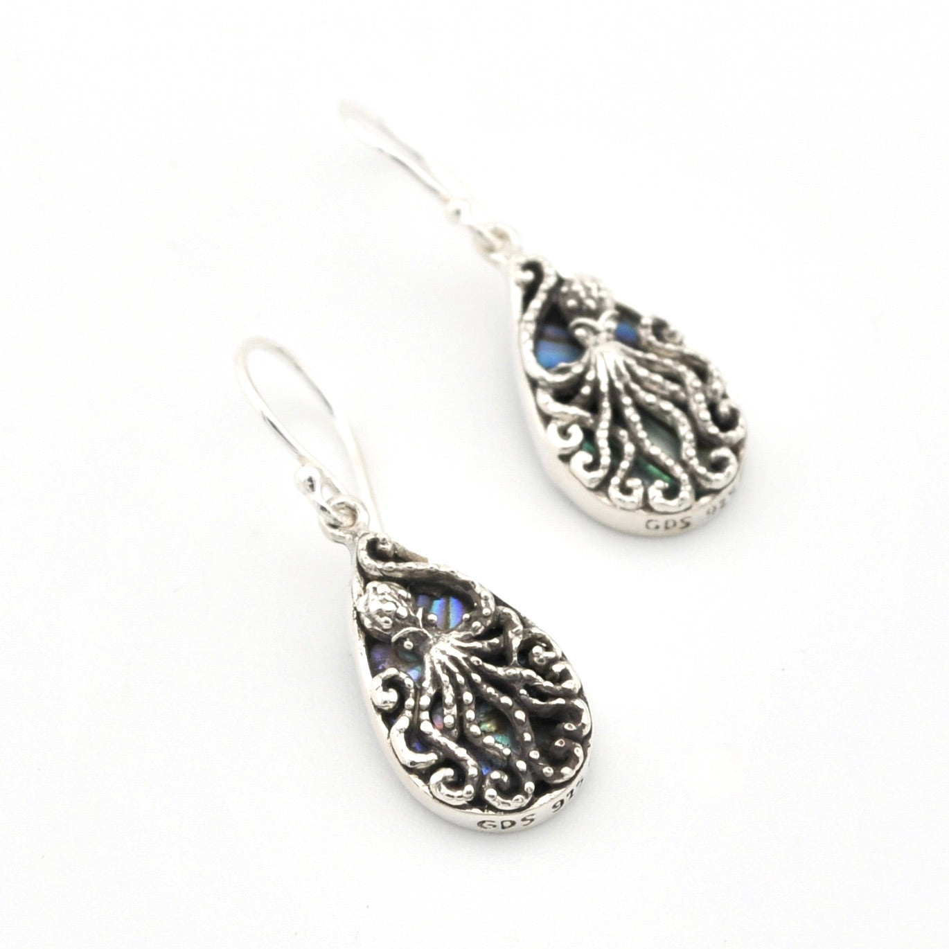 Silver earrings with intricate designs on a white background