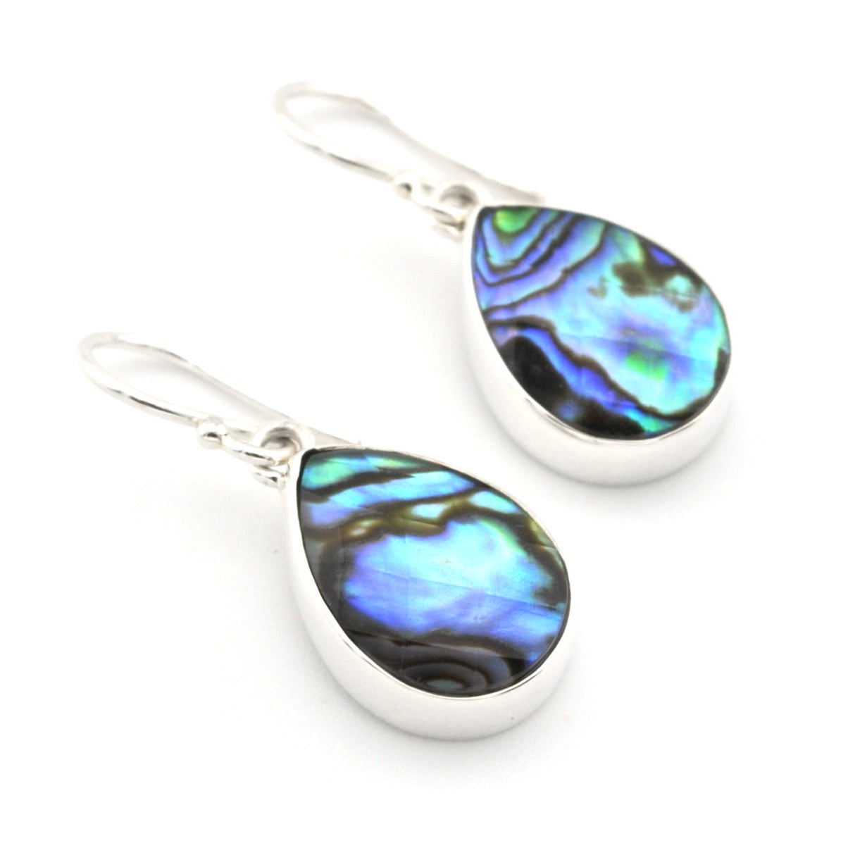 A pair of silver teardrop dangle earrings featuring iridescent abalone shell inlays that shimmer with blue, green, and purple hues, set against a plain white background.
