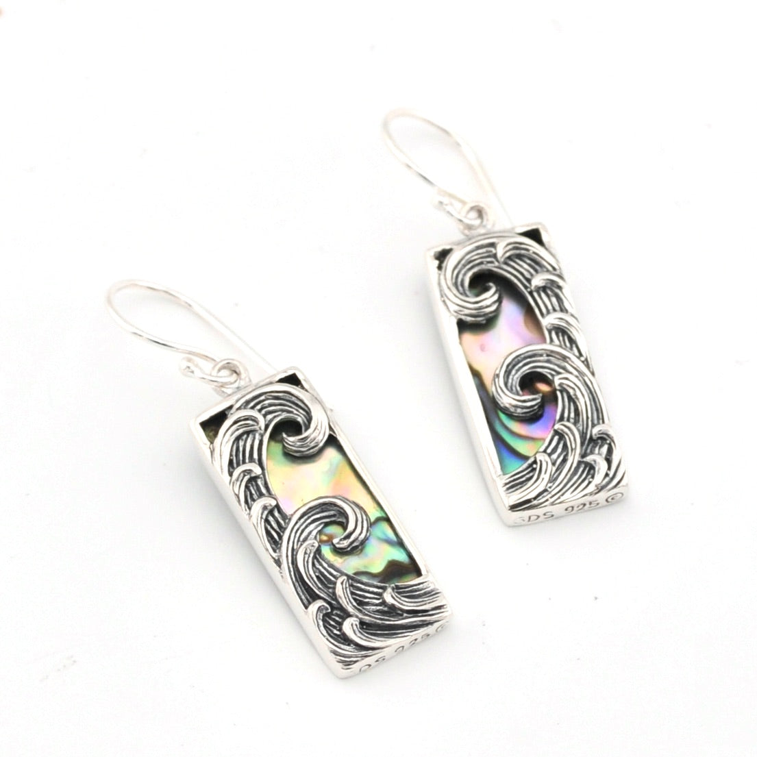 Silver earrings with abalone shell inlay on a white background