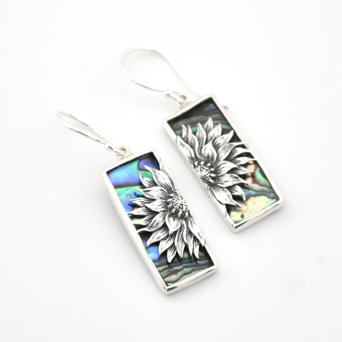 Silver earrings with floral design on a white background