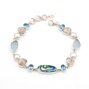 Bracelet with topaz, pearl, sea shell and sea glass on a white background