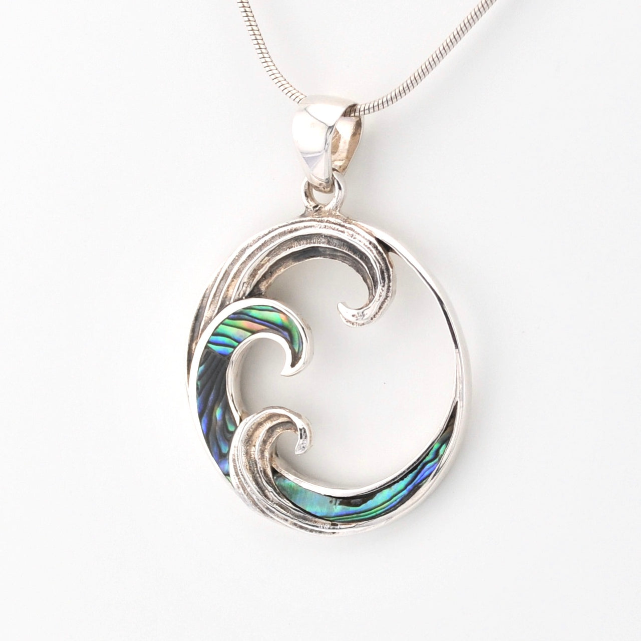 Silver pendant with wave design on a white background