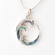 Silver pendant with wave design on a white background