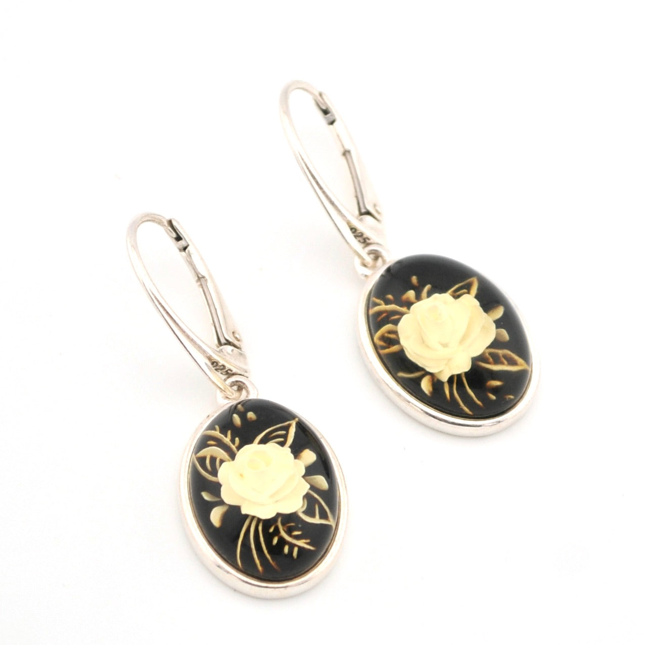 Pair of earrings with black and gold floral designs on a white background