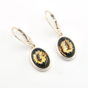 Pair of earrings with black and gold designs on a white background