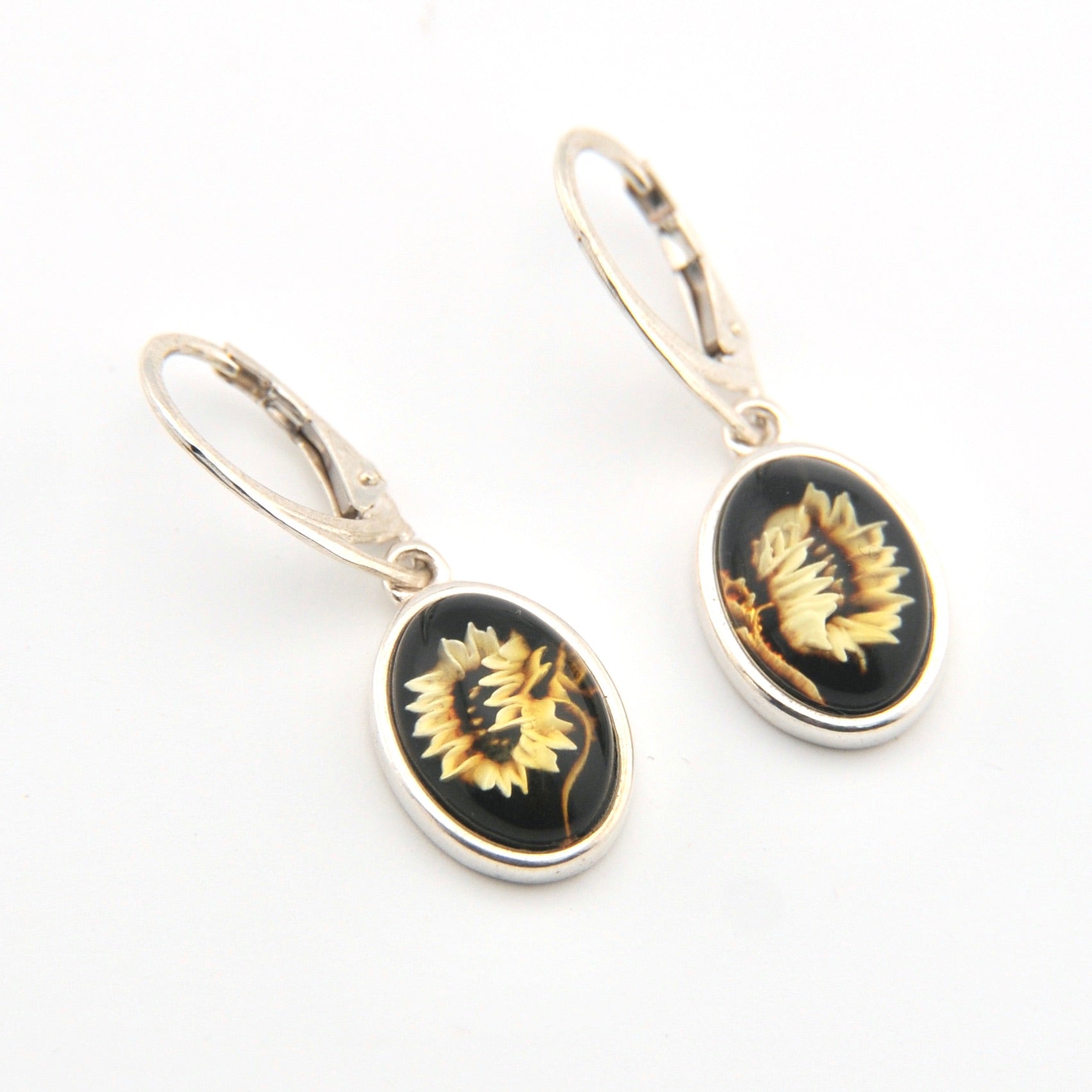 Pair of earrings with black and gold designs on a white background