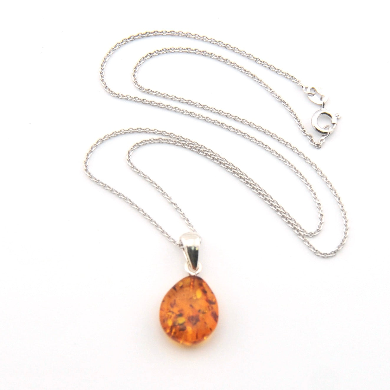 Amber teardrop pendant on a silver chain against a white background